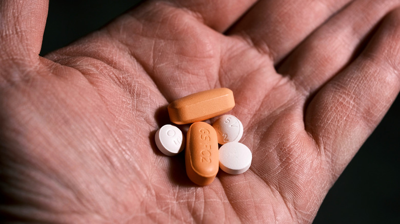 Plusieurs pilules tenues dans la main d’une personne