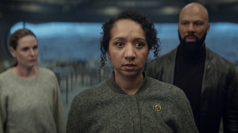 Camille a l'air horrifiée tandis que Juliette et Robert la regardent dans Silo