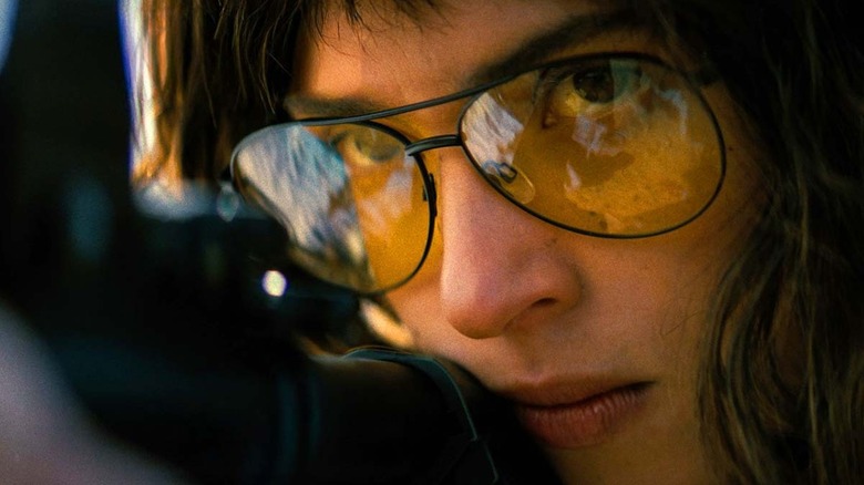 Un gros plan d'Adria Arjona alors que Celeste tire avec son fusil dans Onslaught