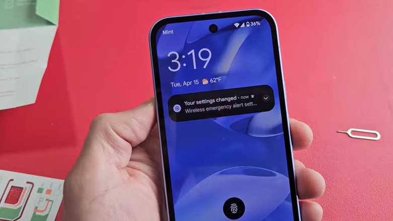 Gros plan d'une personne tenant un téléphone mobile Mint pendant son activation