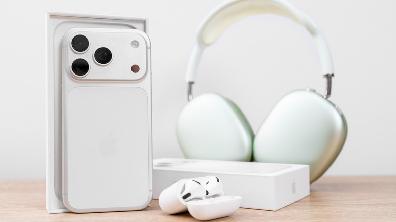 Une photo d'un iPhone 17 Pro, d'AirPods Max 2 et d'AirPods 3 sur une table en bois