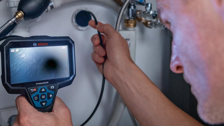 homme utilisant une caméra d'inspection Bosch dans un tuyau