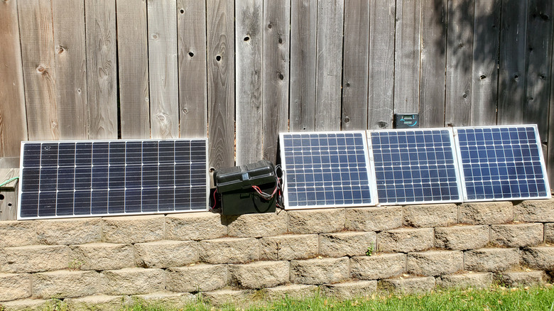 Panneaux solaires Renogy et batterie présentés contre une clôture en bois