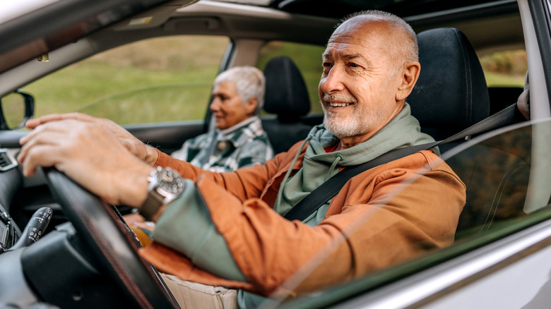 Homme souriant en conduisant la voiture