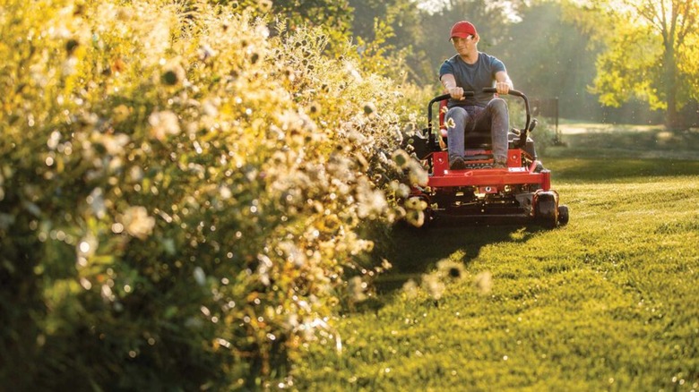 Personne tondant la pelouse avec la tondeuse à rayon de braquage zéro Troy-Bilt