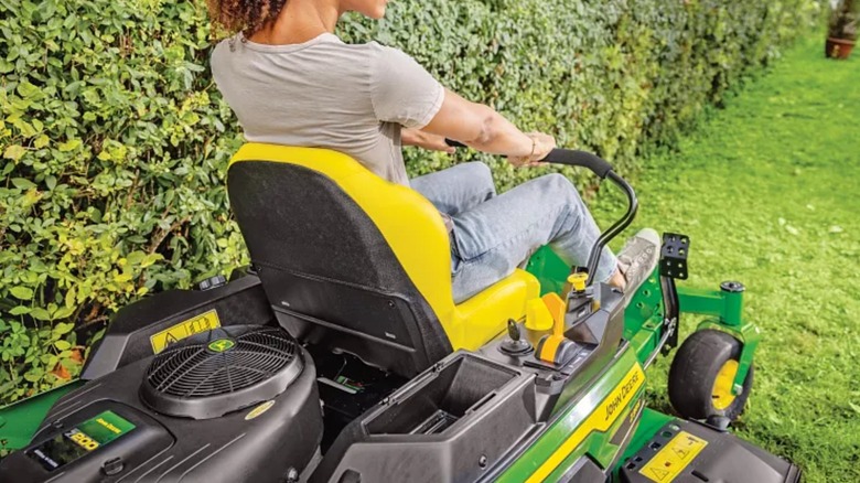 Femme tondant la pelouse avec une tondeuse à rayon de braquage zéro John Deere
