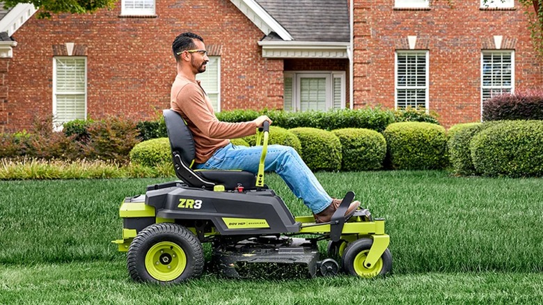 Travailleur tondant la pelouse avec la tondeuse à rayon de braquage zéro Ryobi