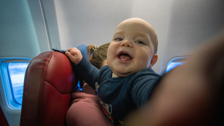 bébé dans l'avion faisant semblant d'être innocent