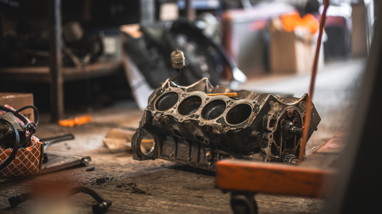 Un bloc moteur en fonte démonté sur un sol d'atelier