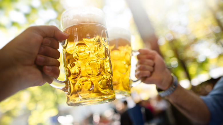 Deux personnes trinquant un verre à l'extérieur dans un café en plein air allemand