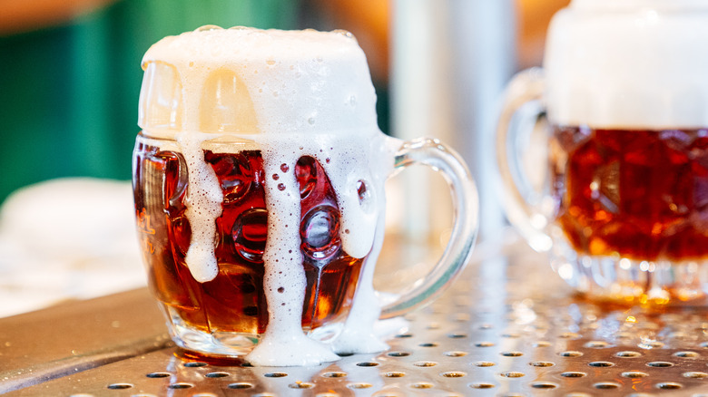 Bière fraîche débordant d'une tasse allemande traditionnelle