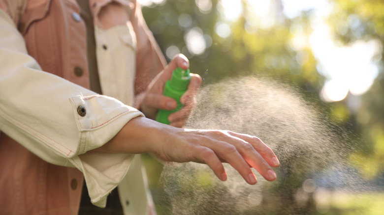 Une personne qui met un insectifuge.