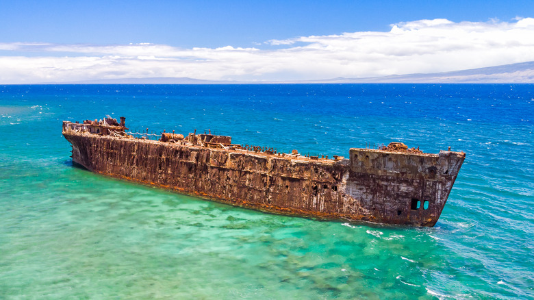 Une épave rouillée dans une eau turquoise au large de Shipwreck Beach sur l'île de Lanai