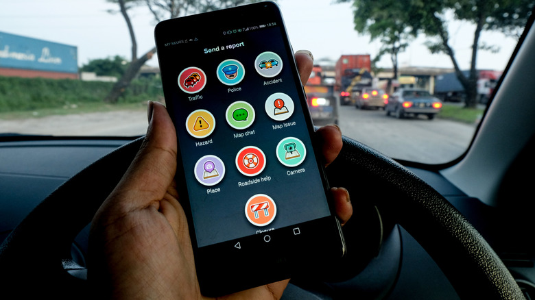 personne tenant un smartphone à l'intérieur de la voiture montrant le 