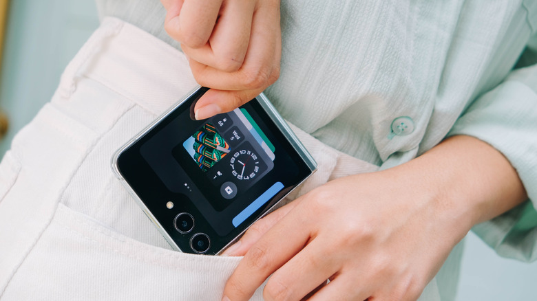 Personne mettant un téléphone Samsung Galaxy Z Flip7 dans sa poche