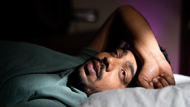 Homme au lit souffrant d'insomnie