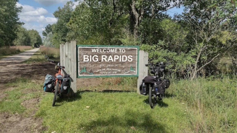 Un panneau indiquant Big Rapids avec des vélos à côté sur le sentier Fred Meijer White Pine.