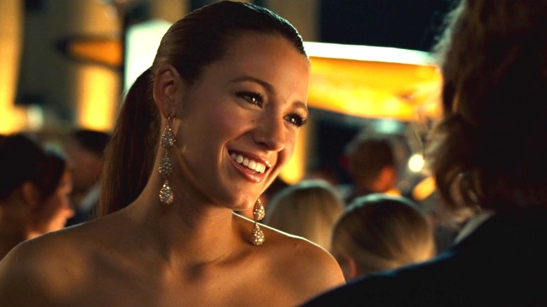 Carol Ferris de Blake Lively sourit alors qu'elle se tient lors d'une fête en plein air à Green Lantern