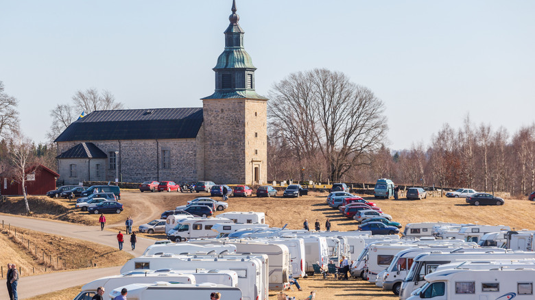 Église de Bjurum avec camping-cars et caravanes au bord du lac Hornborgasjön en Suède