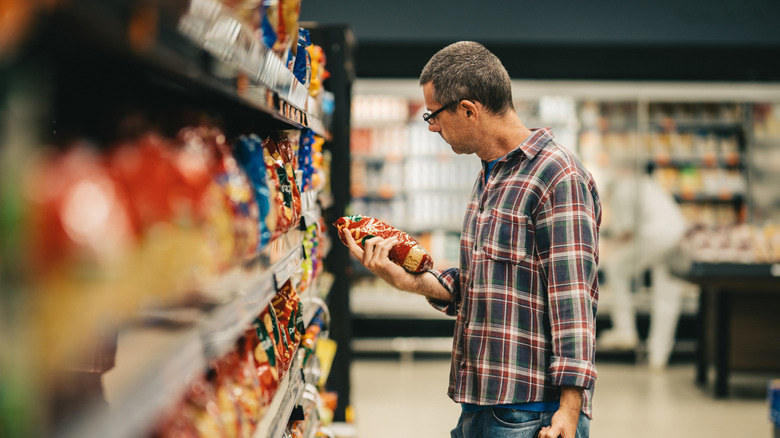 Un homme regardant une étiquette alimentaire dans un supermarché