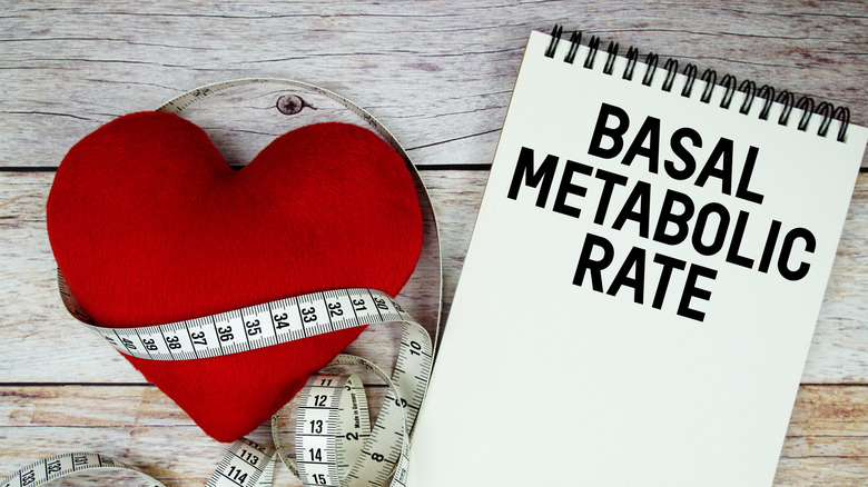 Taux métabolique basal tapé sur le bloc-notes à côté d'un cœur en feutre avec un ruban à mesurer