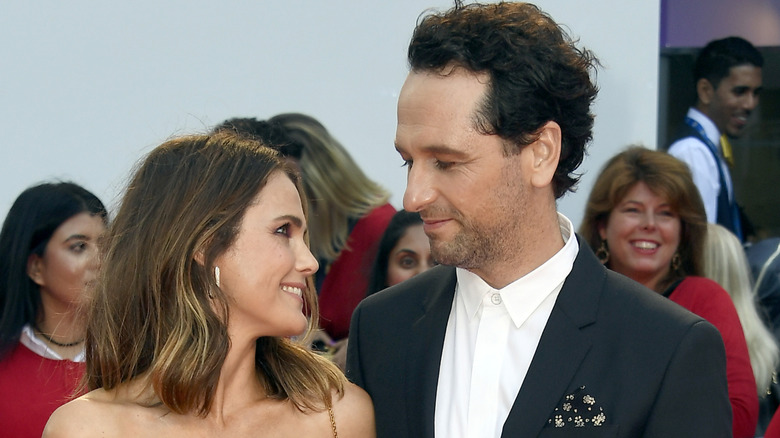 Keri Russell et Matthew Rhys sourient tout en se regardant affectueusement lors d'un événement sur le tapis rouge en plein air