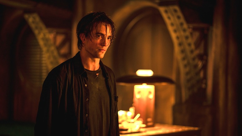 Robert Pattinson dans le rôle de Bruce Wayne debout dans la Batcave avec les cheveux mouillés dans The Batman