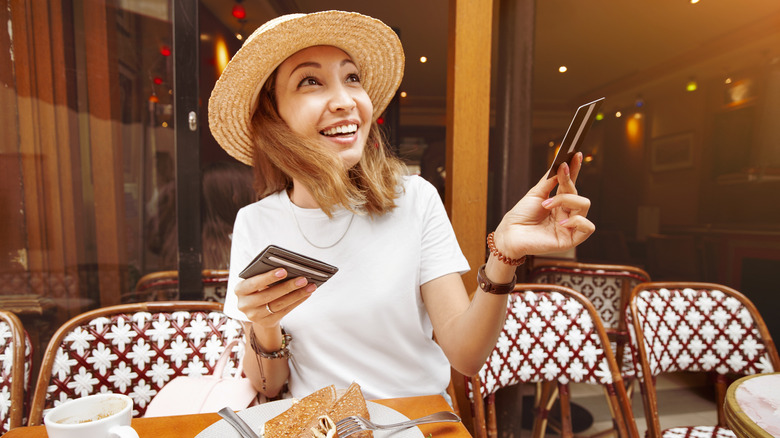 Une femme tendant une carte de crédit à Paris