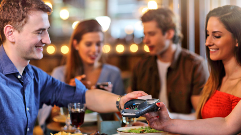 Amis payant une note de restaurant