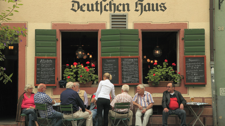 Hommes assis à l’extérieur d’un restaurant allemand traditionnel
