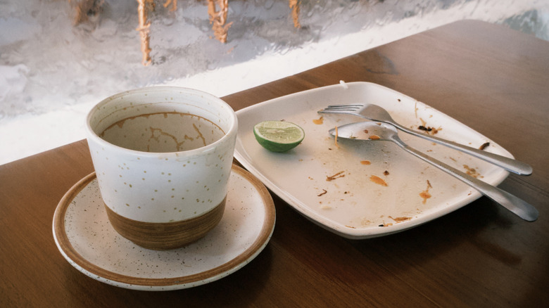 Les assiettes, les tasses et les couverts sont empilés après avoir mangé dans un restaurant