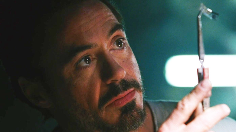 Robert Downey Jr. dans le rôle de Tony Stark construisant son costume dans une grotte dans Iron Man