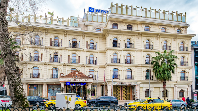 Un grand hôtel Wyndham de couleur crème avec des balcons en fer forgé noir