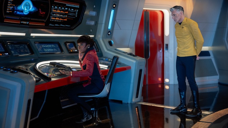 Uhura à la station de communication avec le capitaine Pike qui regarde Star Trek : Strange New Worlds