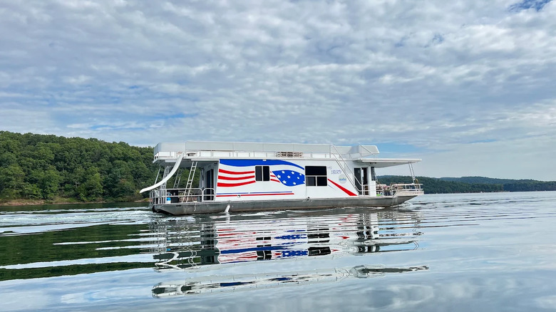 Une péniche rouge, blanche et bleue avec un toboggan flotte sur le lac Raystown