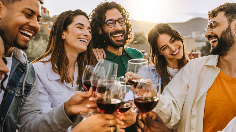 Un groupe de personnes trinquant avec du vin