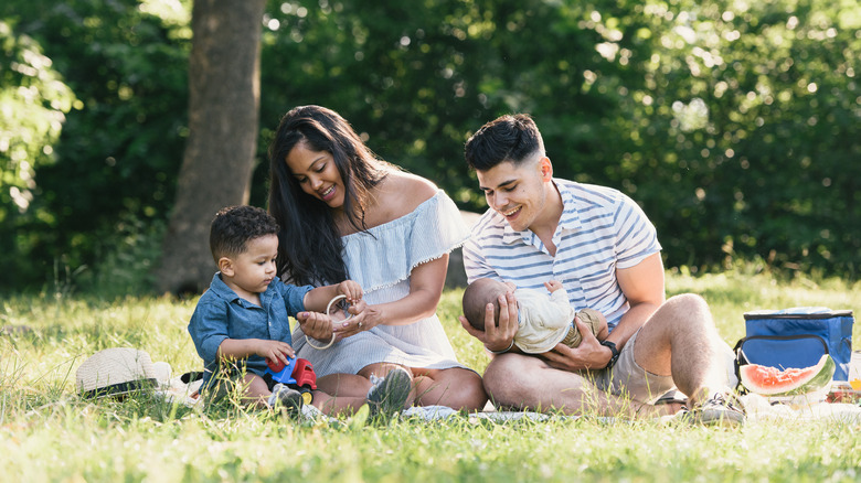 Une famille pique-nique sur l'herbe près des arbres dans le parc Pelham Bay