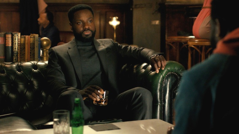 Dayo Okeniyi dans le rôle de Leighton Vance portant un costume et assis sur un canapé en face d'une autre version de lui-même dans Dark Matter