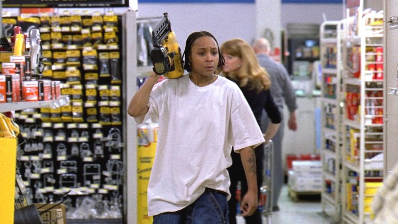 Felicia Pearson dans le rôle de Snoop marchant dans une quincaillerie et brandissant un pistolet à clous dans The Wire