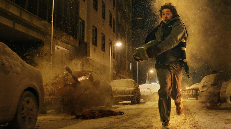 Austin Abrams dans le rôle de Bryan courant dans la rue alors que des corps explosent autour de lui dans Resident Evil (2026)