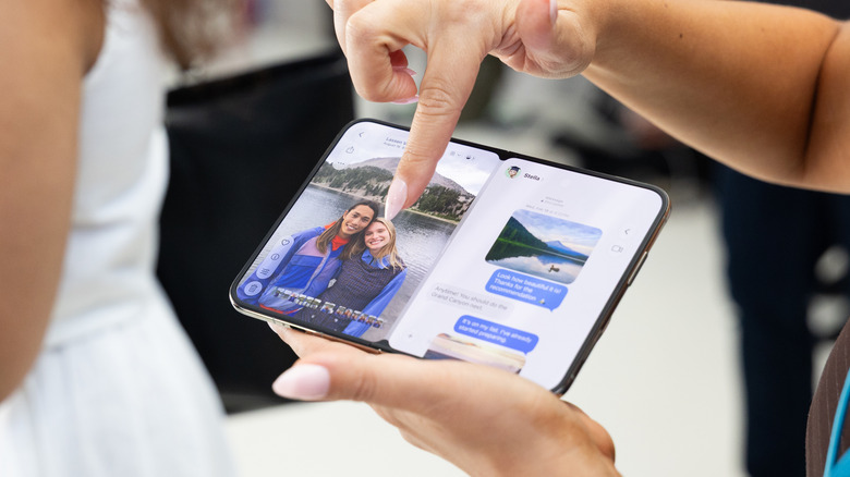 Femme tenant un téléphone iPhone Duo ouvert