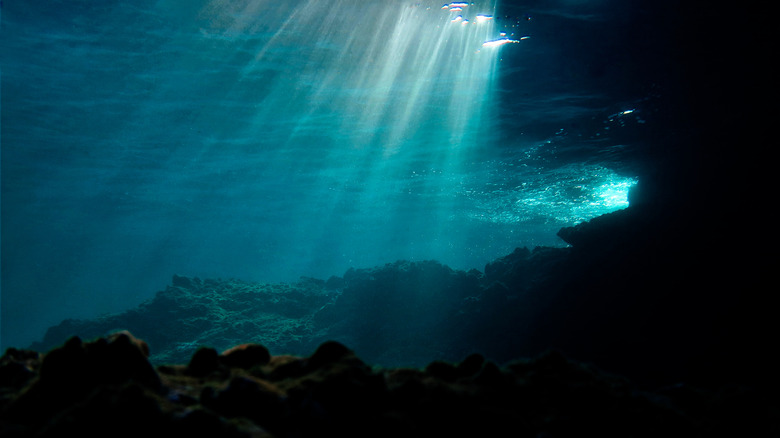Rayons de soleil brillant à travers l'eau de mer sur un récif de corail
