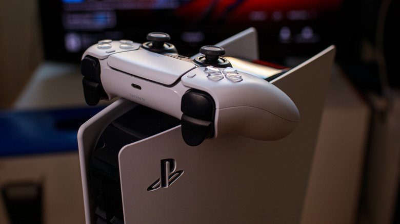 Une manette PS5 reposant sur une console PS5.