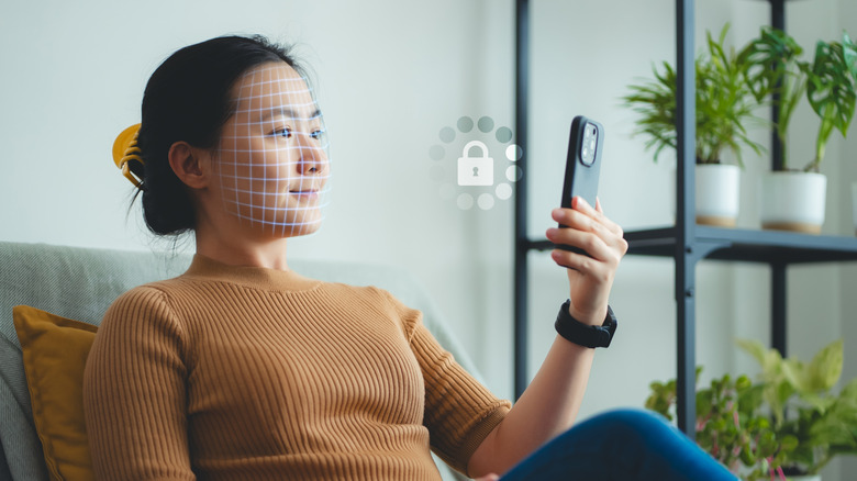 Une femme scanne son visage à l'aide de Face ID sur son iPhone pour le déverrouiller