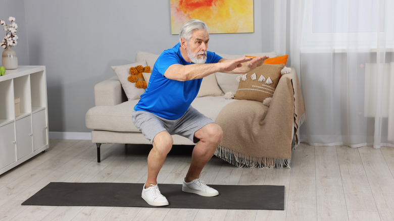 Homme âgé se levant du squat