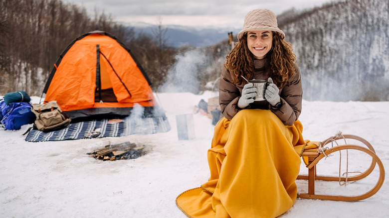 femme souriante au camping enneigé