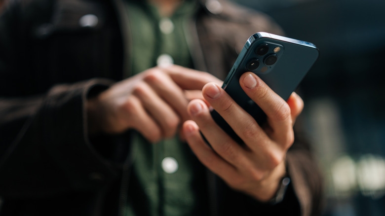 gros plan d'un homme utilisant un smartphone dans une rue de la ville