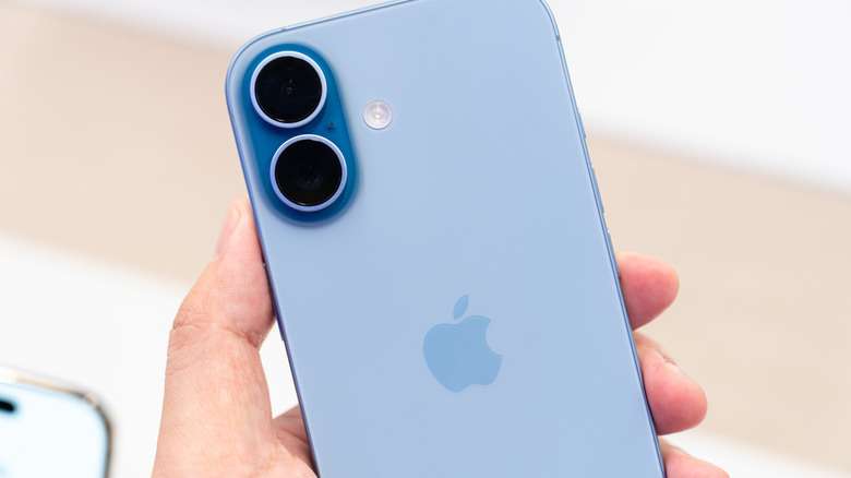 gros plan d'une main tenant un iPhone 17 bleu menthe