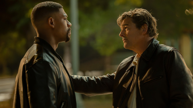 Hal Jordan de Kyle Chandler met sa main sur le bras de John Stewart d'Aaron Pierre alors qu'ils se tiennent face à face dans Lanterns