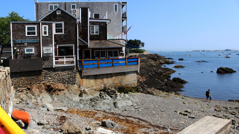 Une petite plage rocheuse avec le restaurant Barnacle en arrière-plan